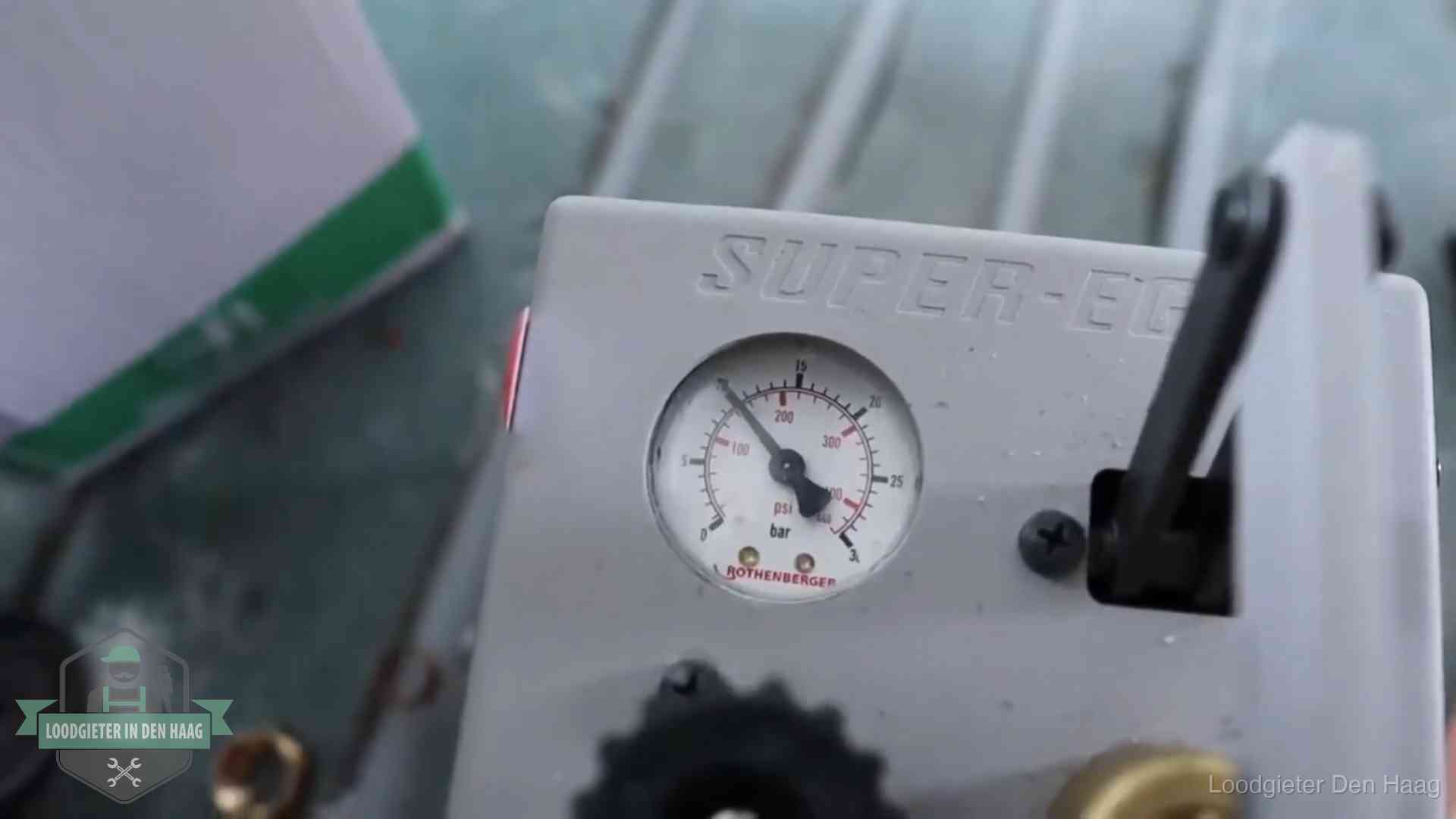 Manometer van een afperspomp bij controle van nieuw leidingwerk in Den Haag