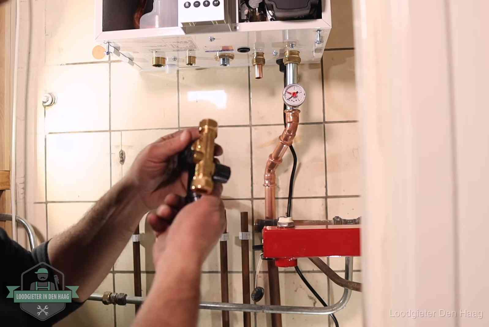 Vulkraan en manometer onder een cv-ketel voor het bijvullen van de waterdruk in Den Haag