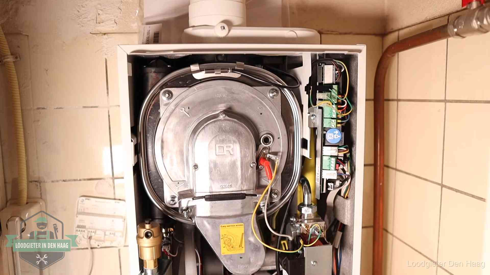 Geopende cv-ketel met warmtewisselaar tijdens periodiek onderhoud in Den Haag