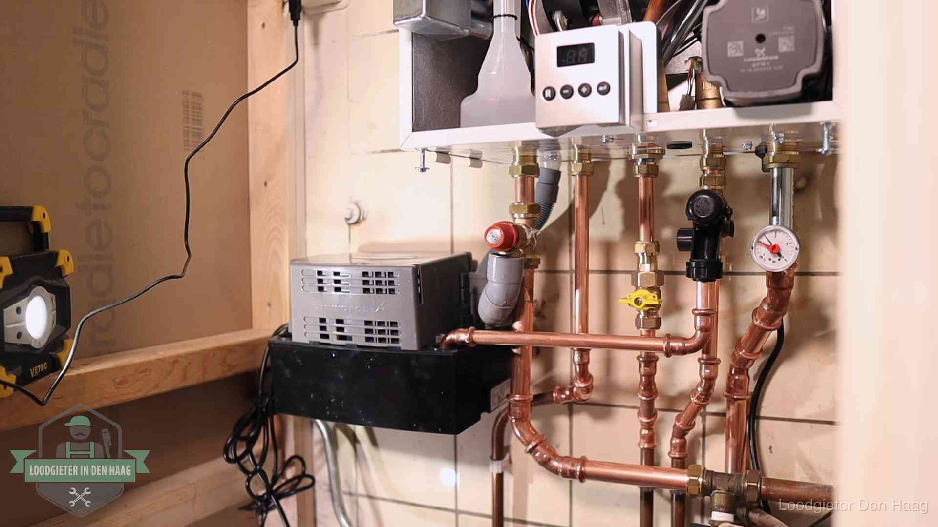 Nieuw koperen leidingwerk met pomp en manometer onder een vervangen cv-opstelling in Den Haag