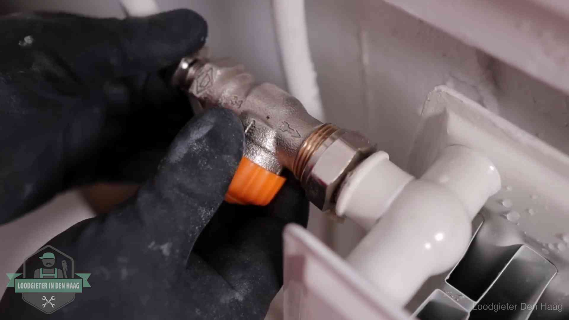 Thermostaatkraan wordt gemonteerd op een radiator in Den Haag voor het stookseizoen