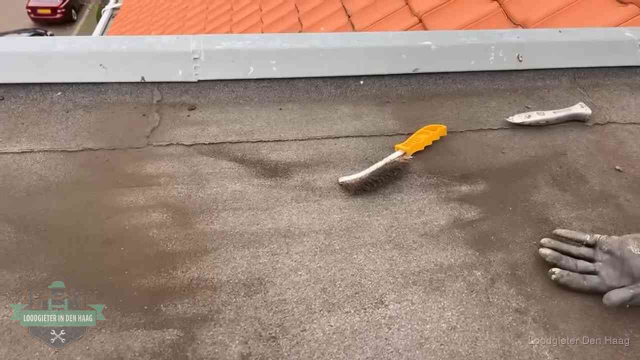Dakdekker bereidt een bitumen plat dak voor op reparatie bij de daktrim in Den Haag