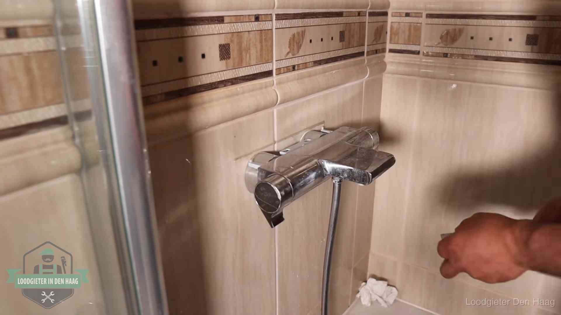 Verkalkte douche-mengkraan in Den Haag, hetzelfde kalk dat zich in de warmtewisselaar afzet