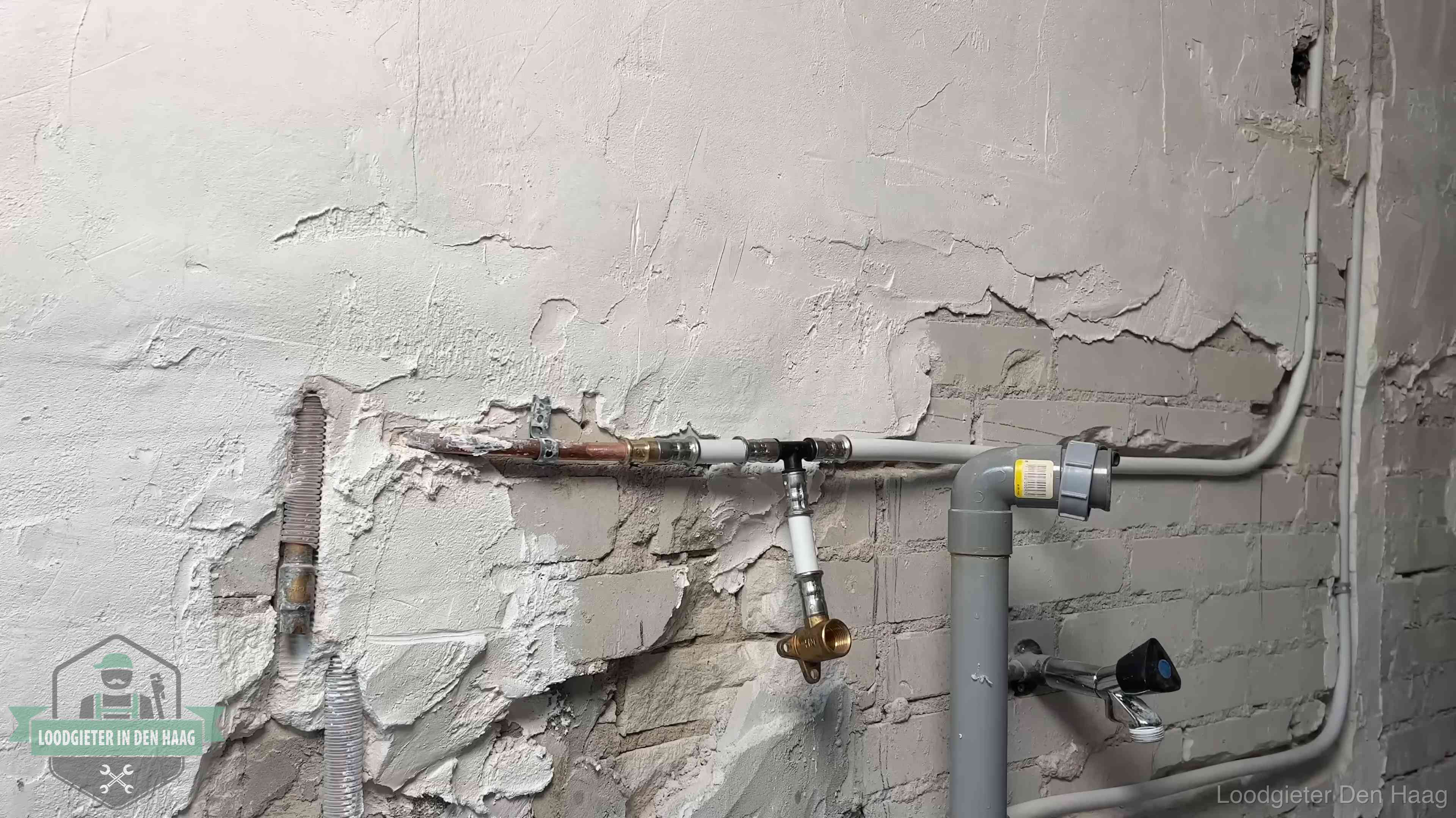 Nieuw leidingwerk naast een oud verroest leidingrestant in een woning in Den Haag