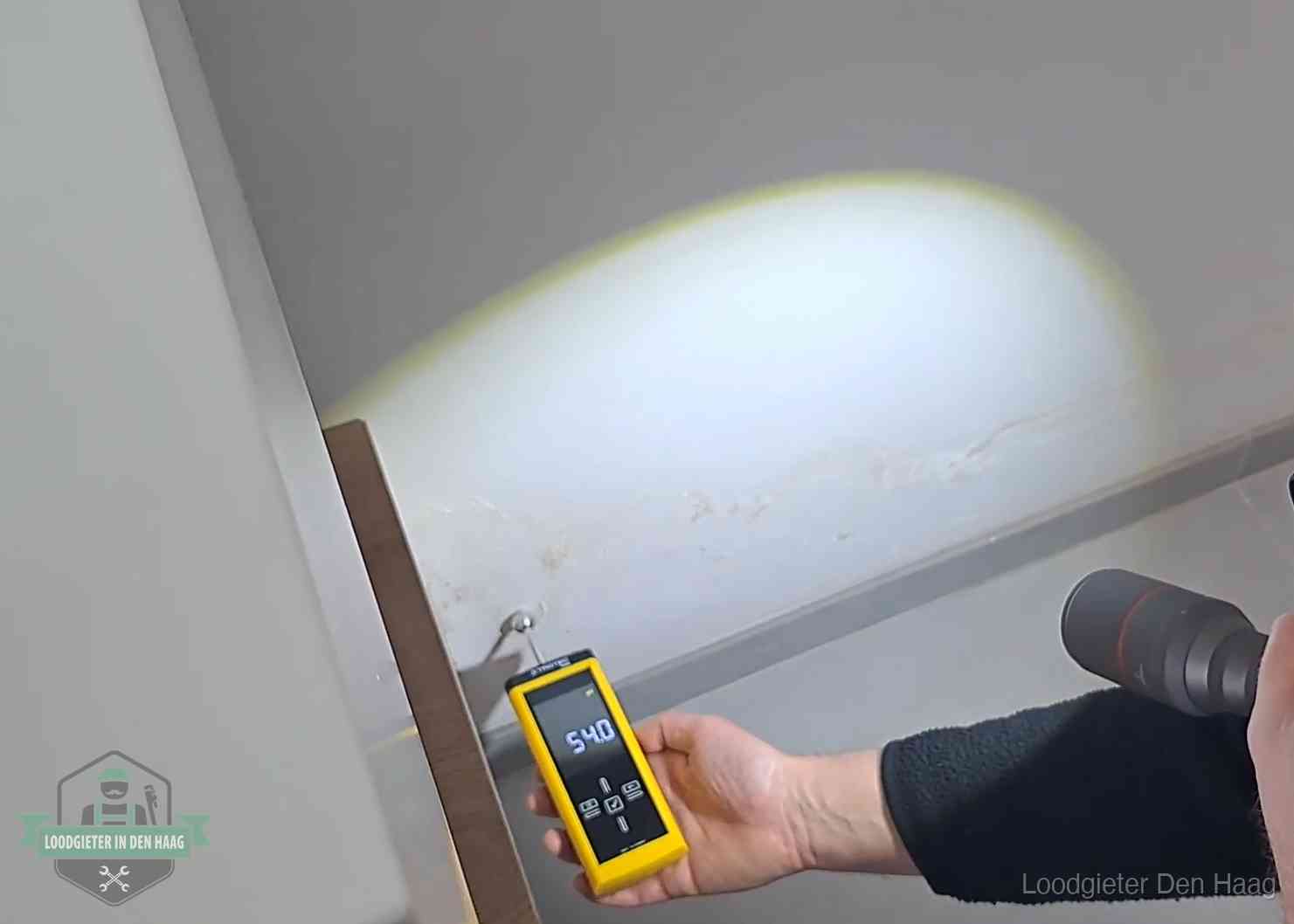 Lekdetectie-technieken in Den Haag Vochtmeter tegen een natte wand met lekkagesporen in Den Haag