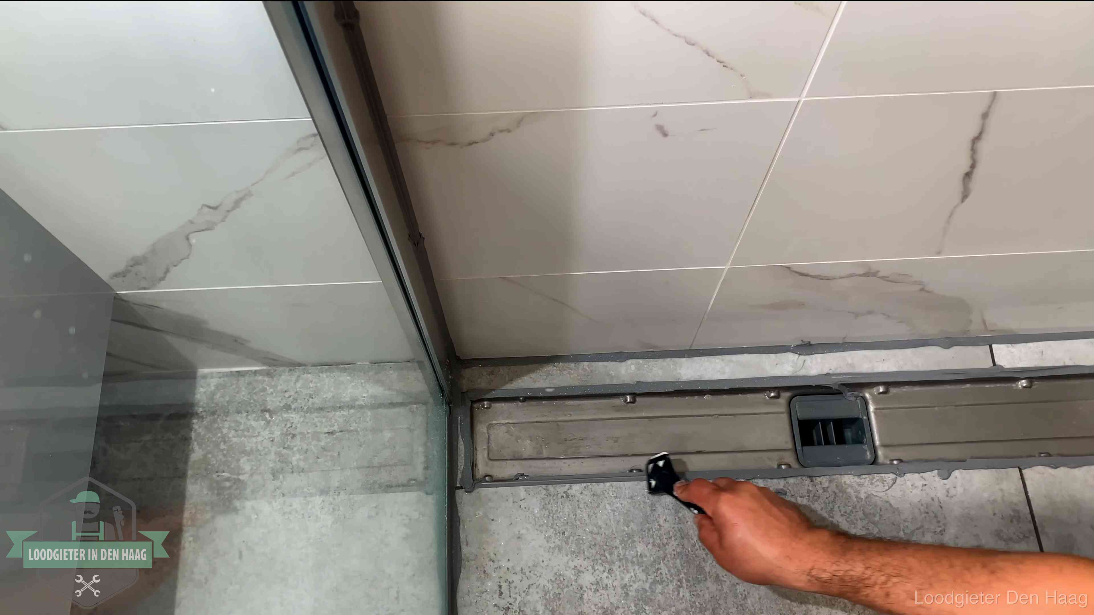 Lekkage in de badkamer verhelpen in Den Haag Verse kitrand langs de douchegoot in een betegelde badkamer in Den Haag
