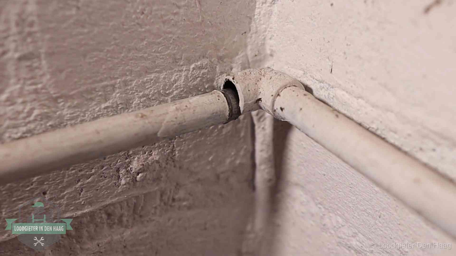 Oude waterleidingen en verborgen lekkage in Den Haag Oude geverfde waterleiding met een losliggende fitting in een woning in Den Haag