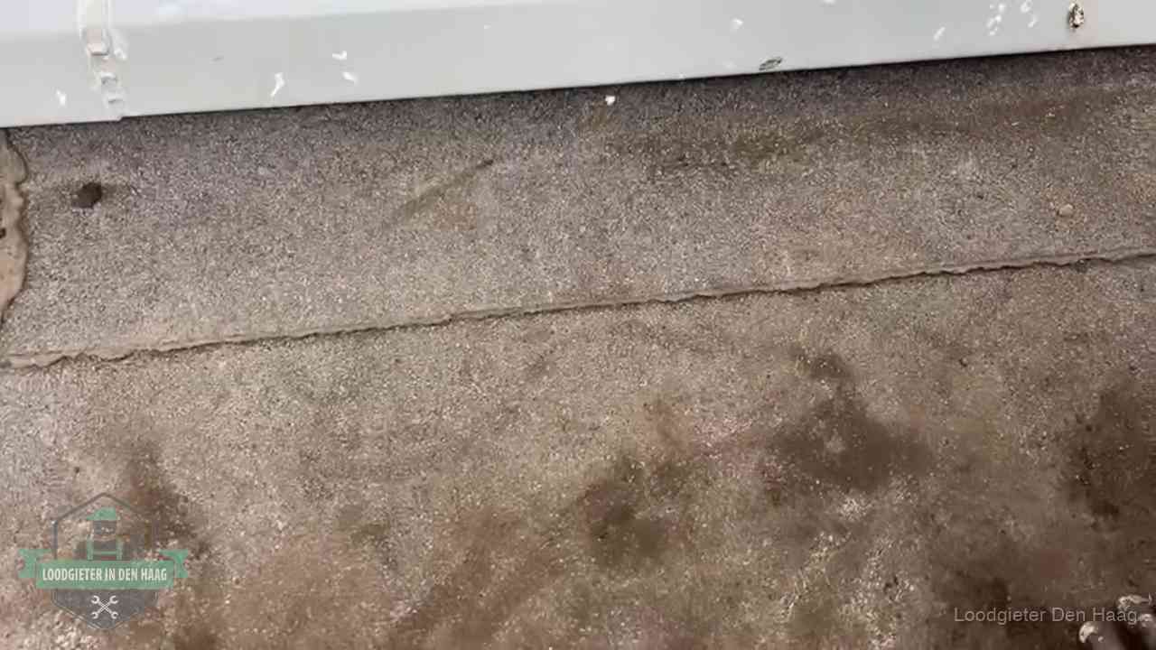 Vochtplekken bij de naad van een plat dak na aanhoudende regen in Den Haag