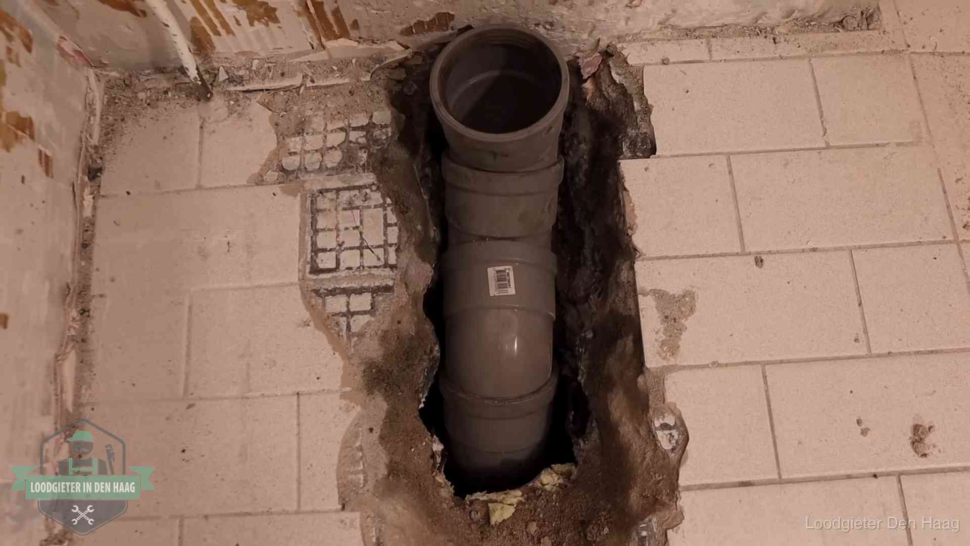 Nieuwe rioolleiding in een opengehakte vloer van een woning in Den Haag