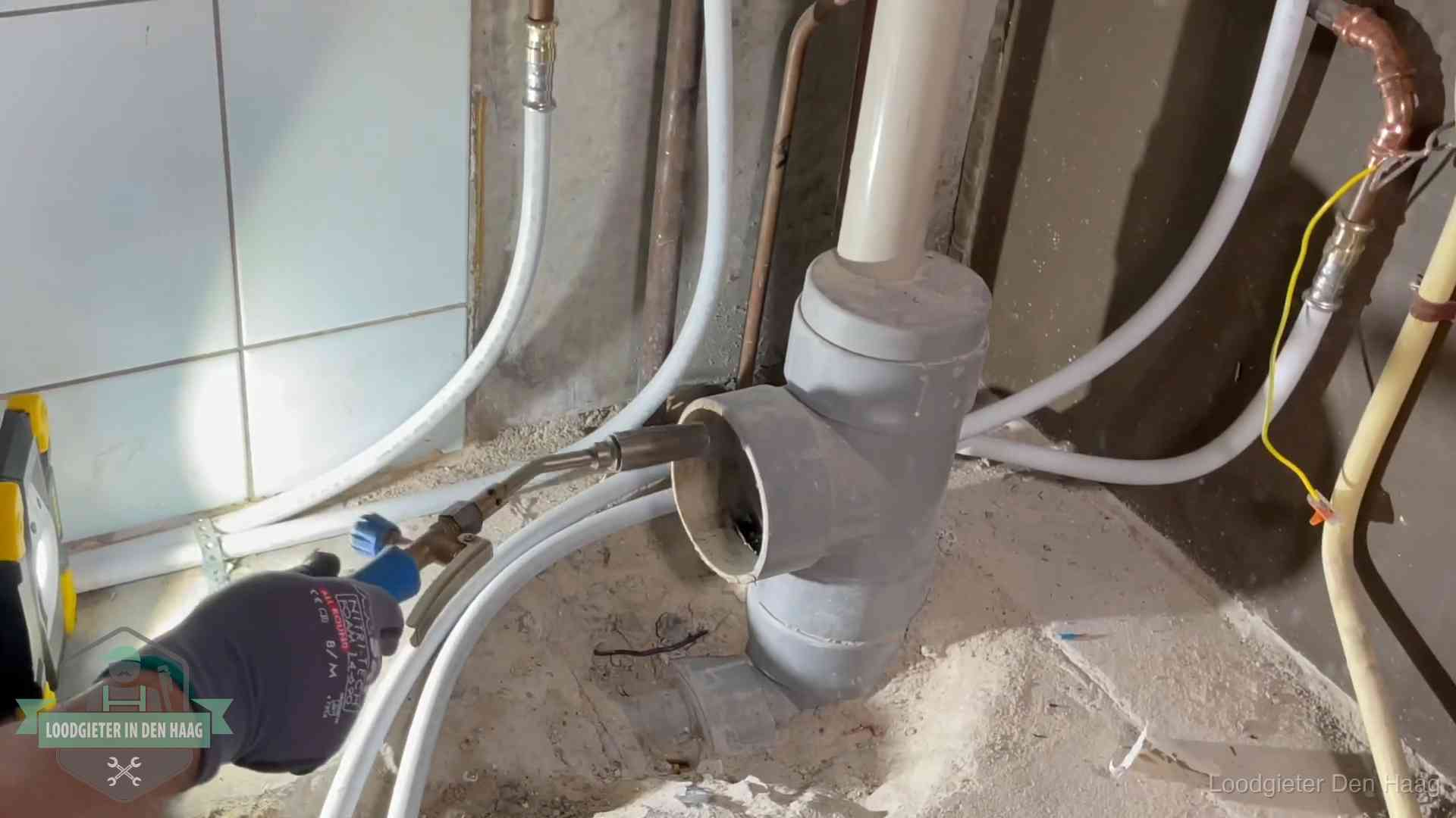 Loodgieter werkt aan leidingen bij de pvc-standleiding van een huurwoning in Den Haag
