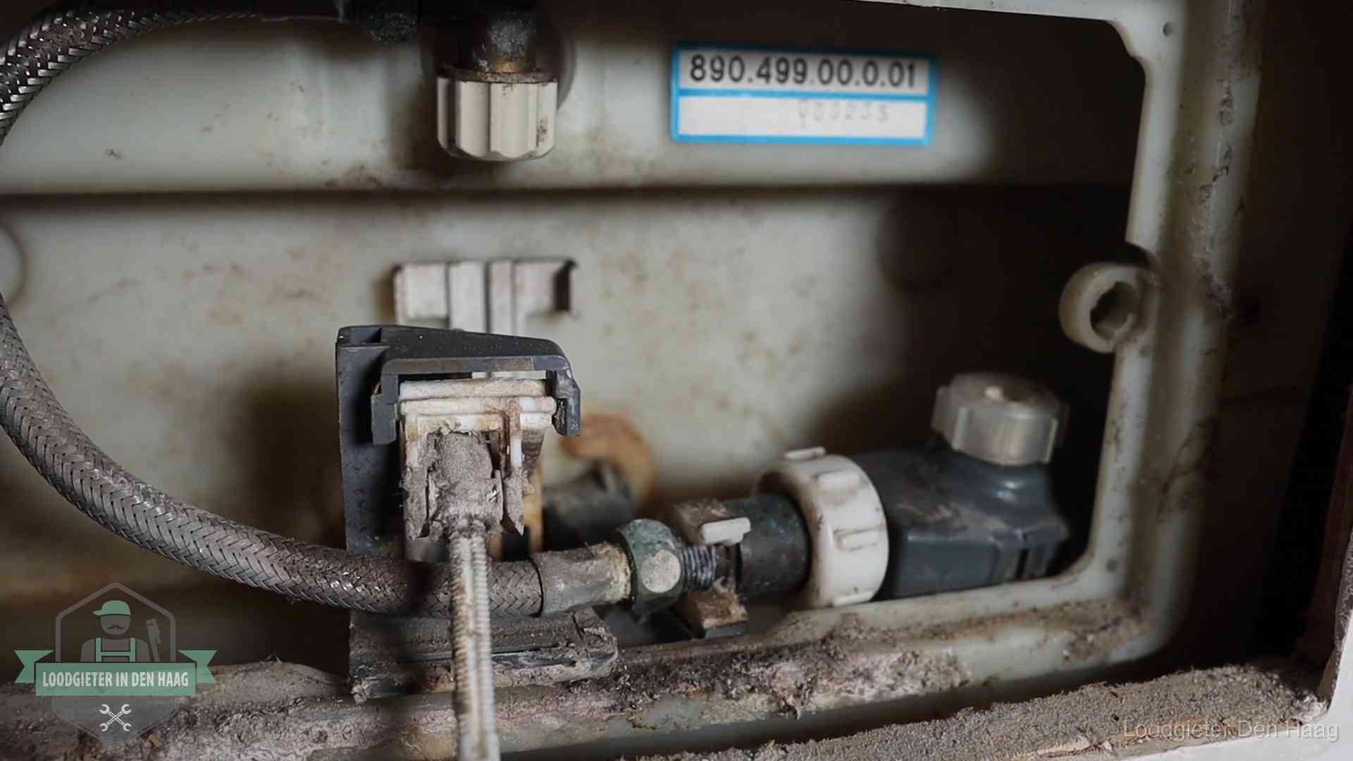 Verkalkt binnenwerk van een stortbak met vlotterkraan in Den Haag