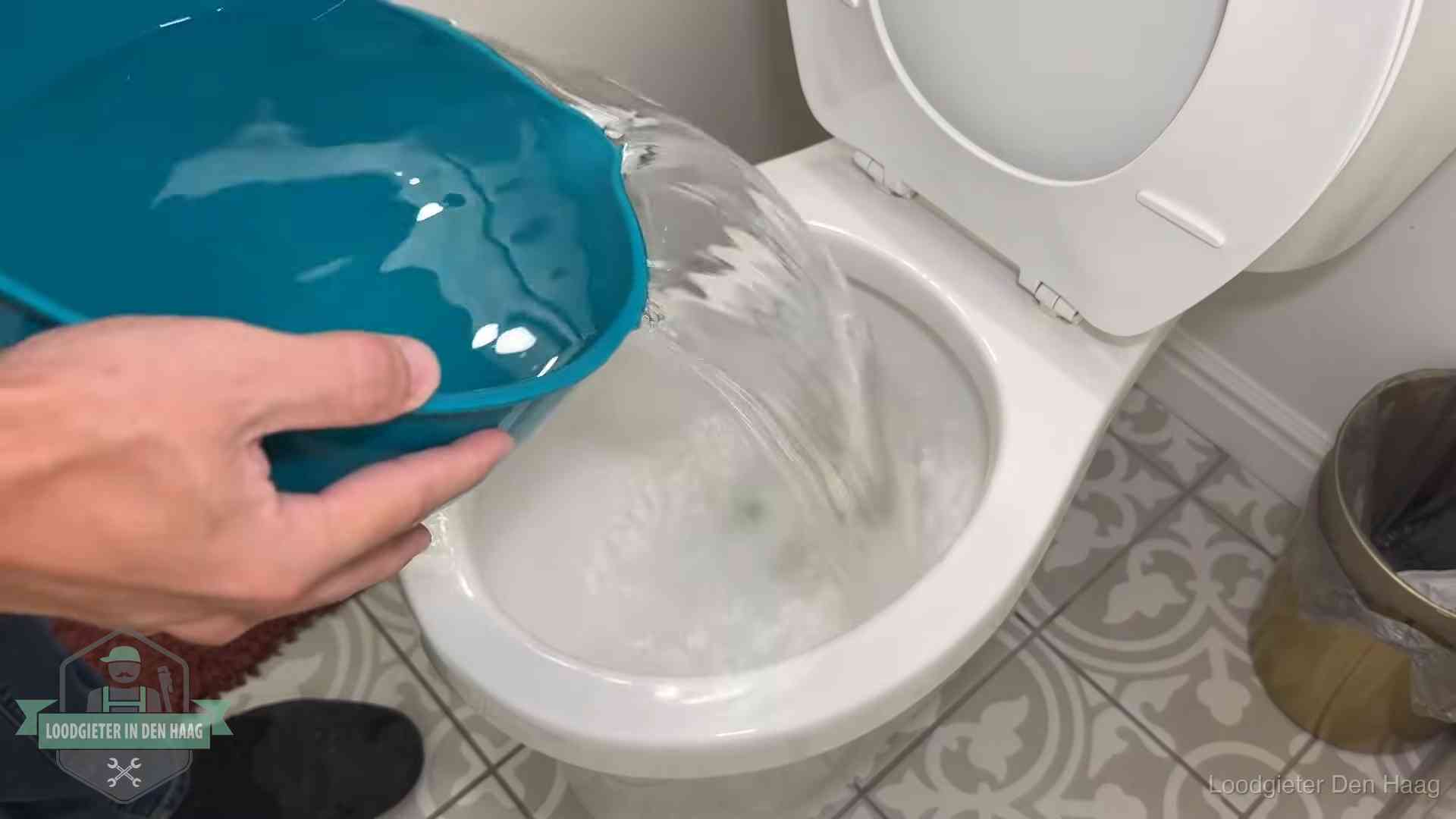 Warm water wordt voorzichtig in de wc-pot gegoten in Den Haag