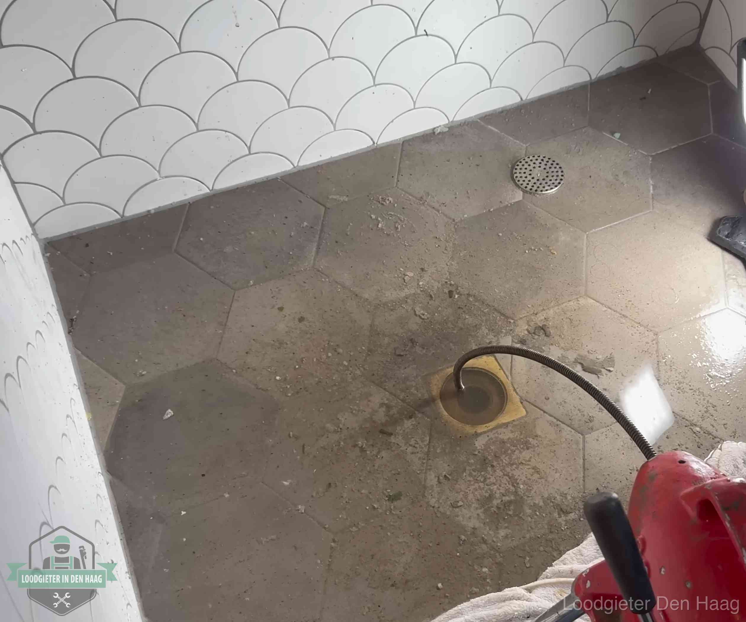 Vloerput met waterslot in een badkamer in Den Haag, een bron van stank als het waterslot droogstaat