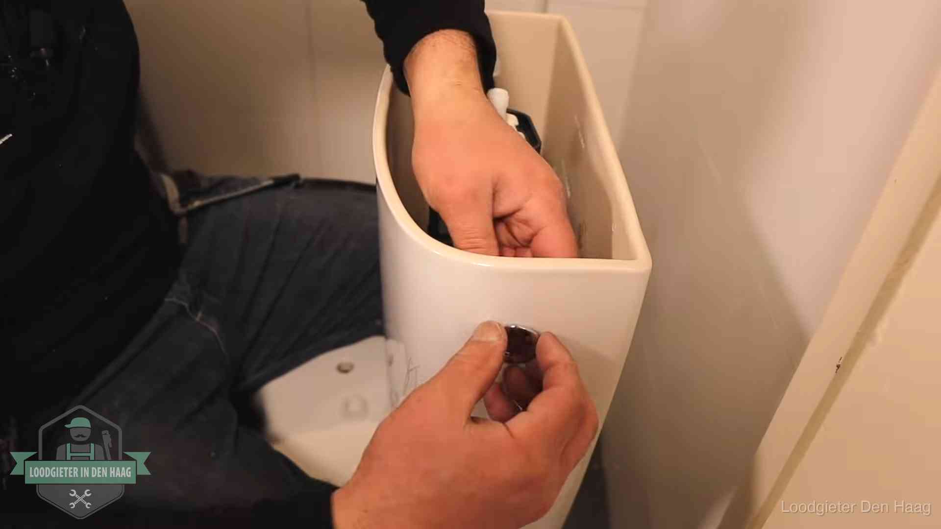 Drukknop van een duoblok-stortbak wordt gemonteerd bij een toilet in Den Haag