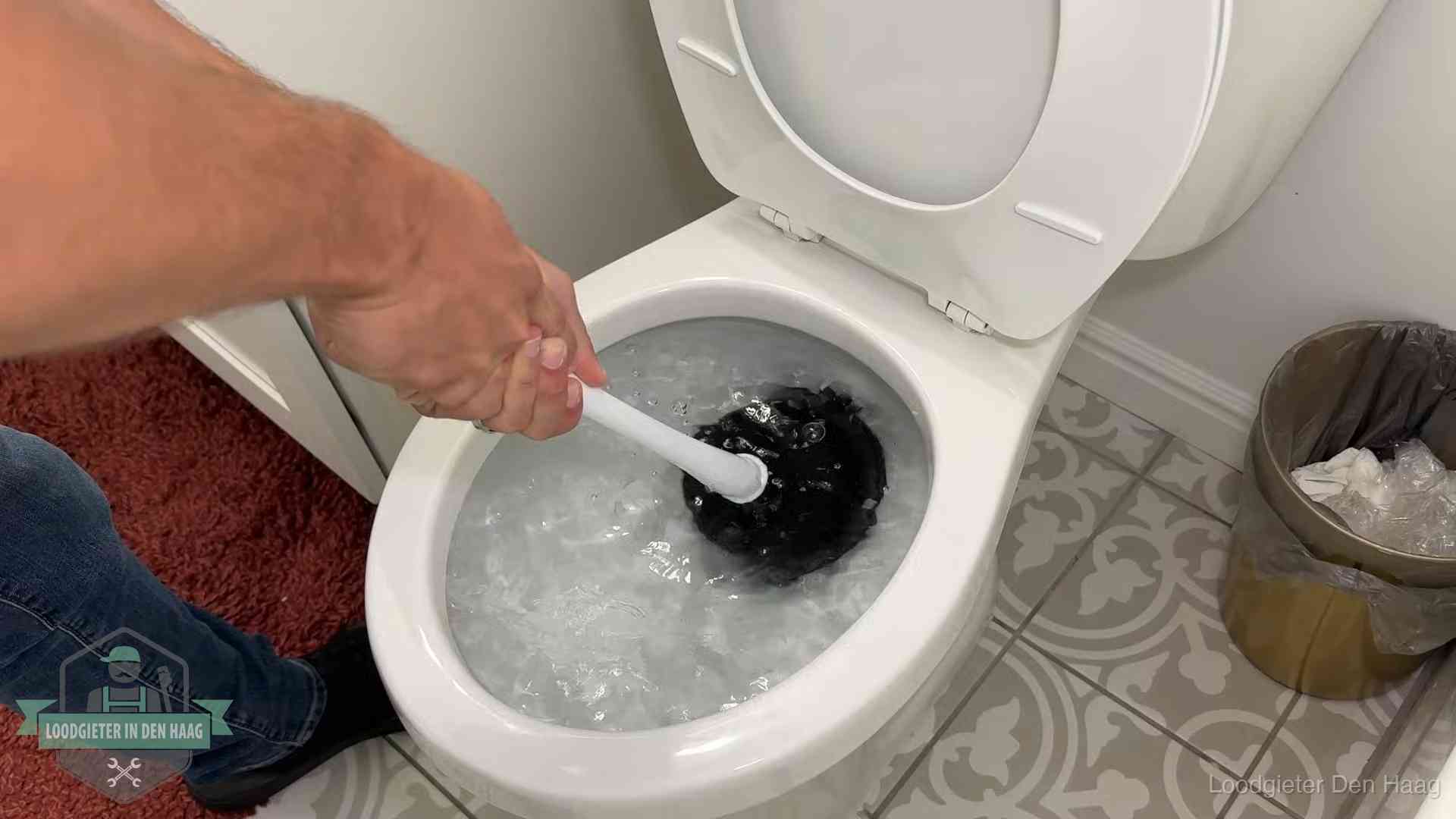Zelf de wc ontstoppen met een plopper in Den Haag, het water kolkt in de pot